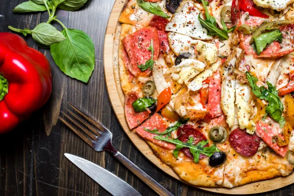 mixed pizza sausages chicken arugula olives cheese pepper top view