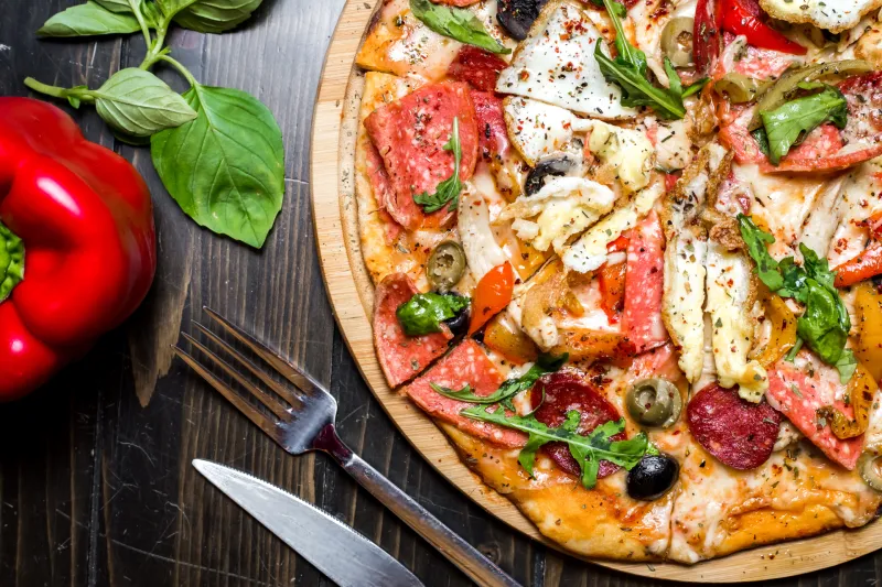 mixed pizza sausages chicken arugula olives cheese pepper top view