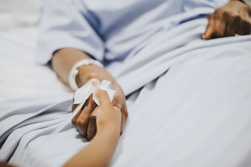 Daughter holding her mothers hand in the hospital, freepik