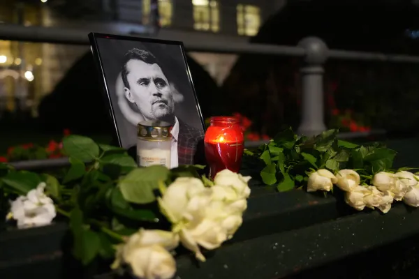 Portret Charlieja Kirka stoji poleg cvetja na bdenju. Foto: STA