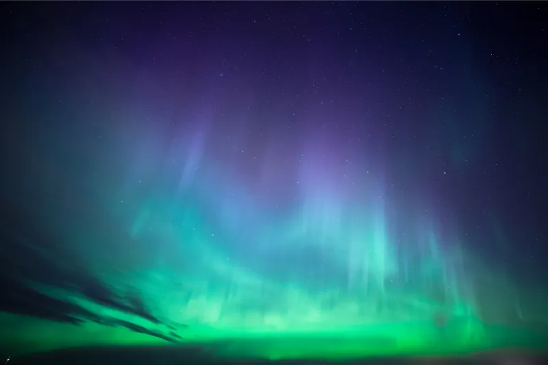Severni sij, znan tudi kot aurora borealis, je pojav, ki se pojavlja v bližini Zemljinih polov, nastane pa, ko magnetno polje planeta usmeri nabite delce Sonca v ozračje. Foto: Canva