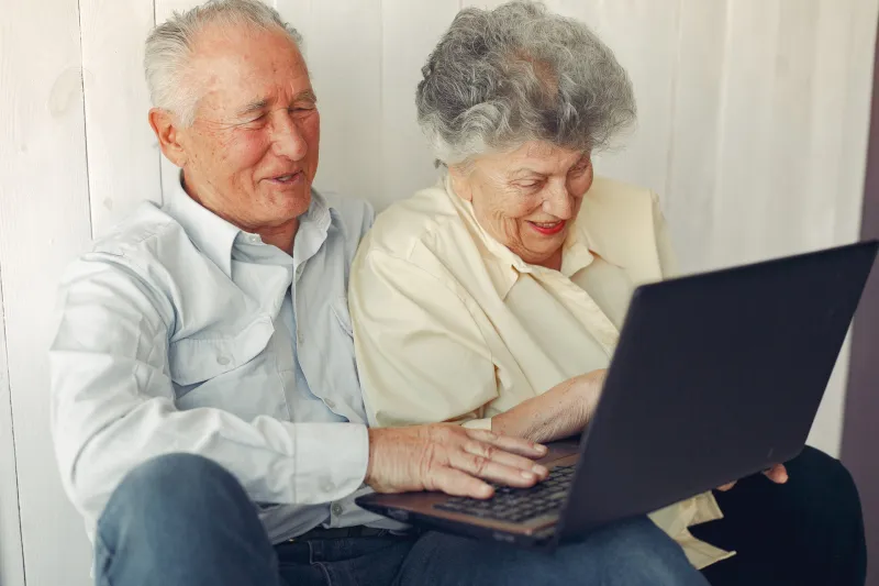 Grandparents at home. Old people use the laptop. Senior in a blue shirt.
