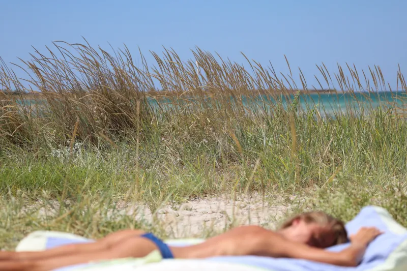 Trend je povezan z estetiko healthy glow, clean girl summer, Euro summer in z vrnitvijo videza iz zgodnjih 2000-ih, ko je bil zelo temen ten modni ideal. Foto: Canva